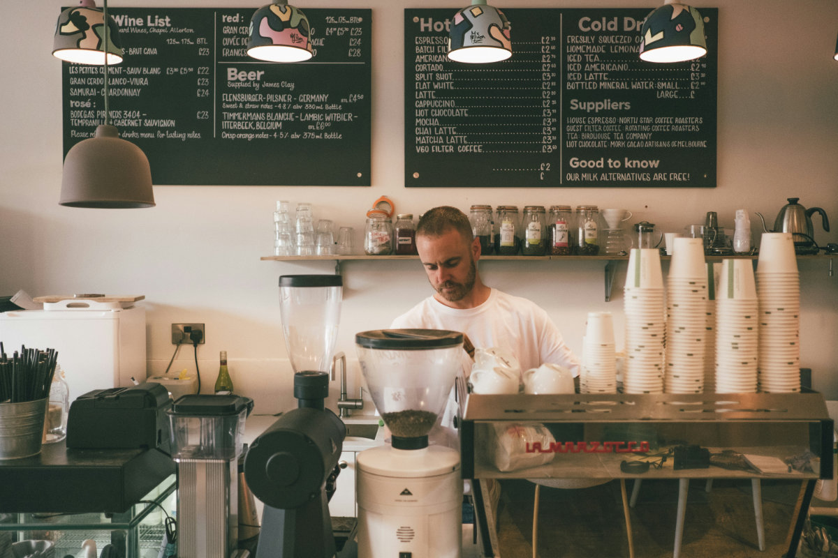 A man works in his cafe, focusing on his work, knowing that his website is taken care of.